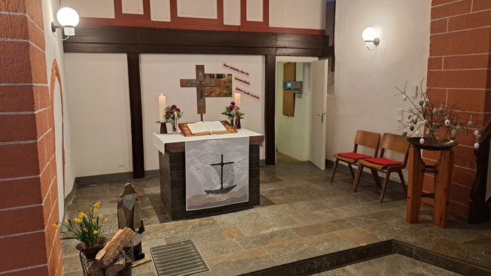 Kleine Kapelle mit Altar, Kerzen und Holzbänken