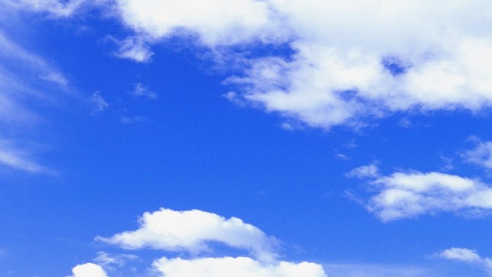 Rolling green hills under blue sky with white clouds