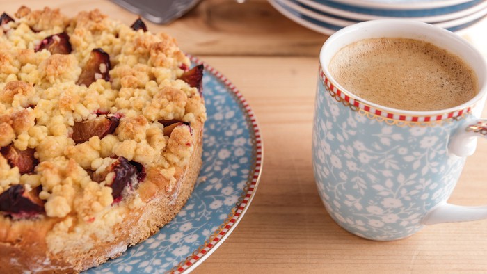 Ein Kuchen und eine Tasse Kaffee auf einem Holztisch