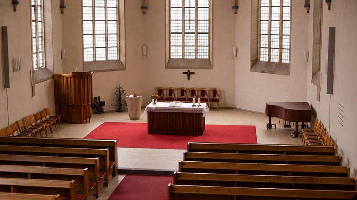 Die Kirche hat hölzerne Bänke und hohe Fenster.