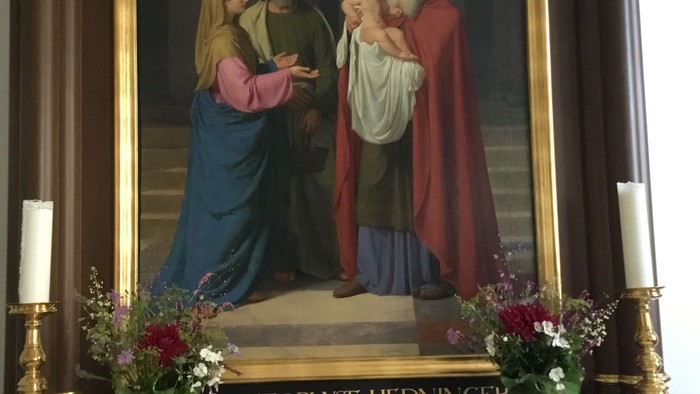 Altaret i kirken med maleri af Jesus og hans forældre