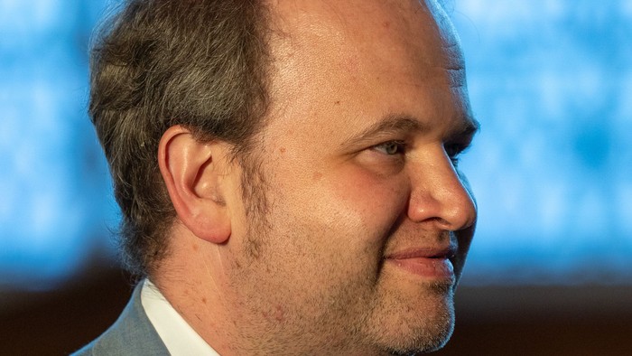 Mann im Anzug mit Krawatte, leicht lächelnd