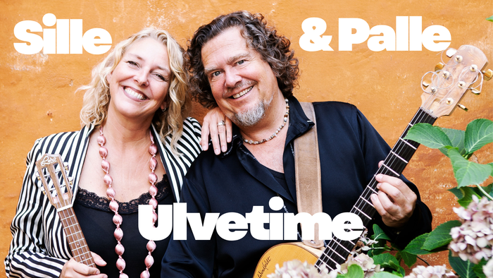 Et smilende par poser sammen med en guitar, mærket som Sille & Palle til deres album *