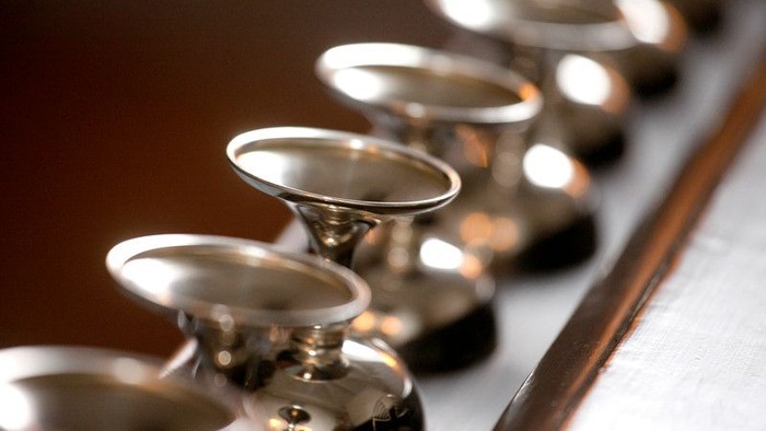 En rekke sølvbåde stillede op på en bord.