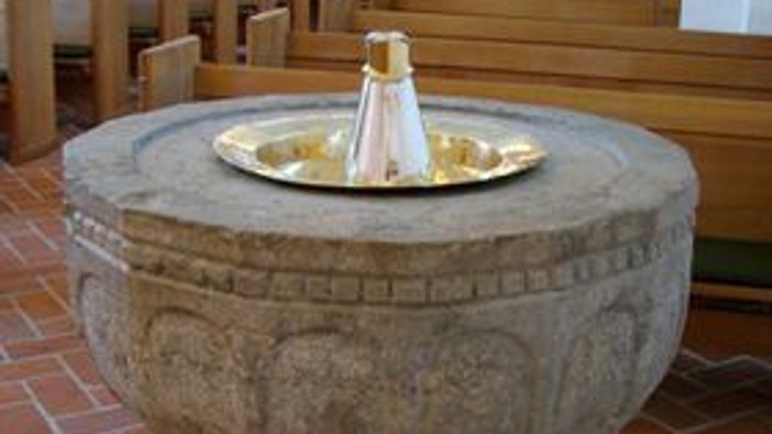 En stor steenfontæne med vand i midten af et rum med bord og stoler.