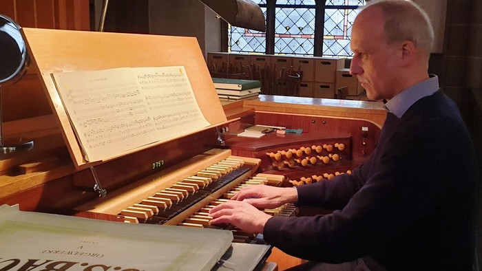 Mann spielt Orgel in Kirche