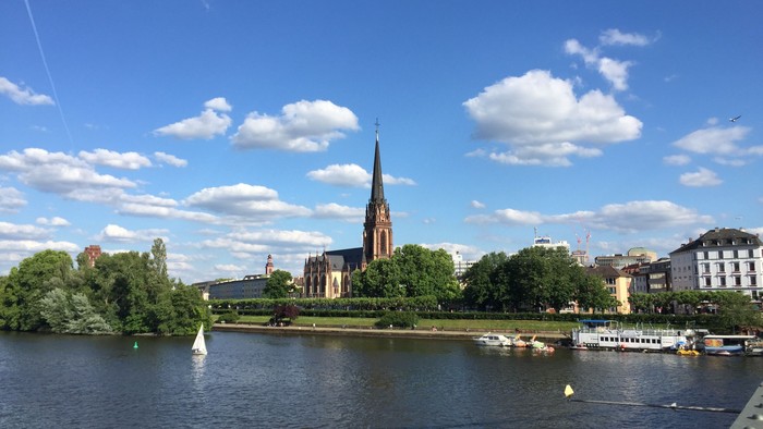 Ein Fluss mit Booten, Kirchen und Gebäuden unter blauem Himmel