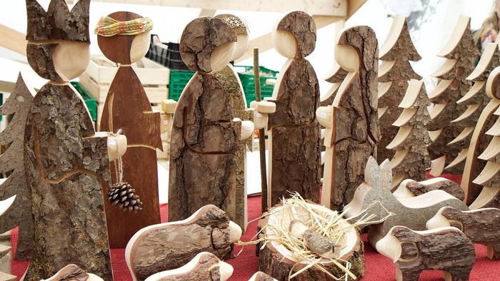 Holzskulpturen von Menschen und Tieren auf rotem Stoff