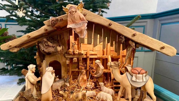 Die Krippe zeigt Jesus, Maria, Josef und Tiere in einer Holzscheune