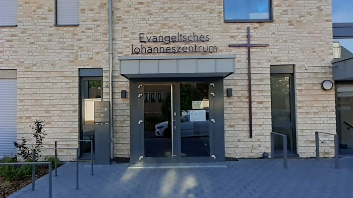 Modernes Gebäude mit großer Glastür und Schriftzug "Evangelisches Krankenhaus"