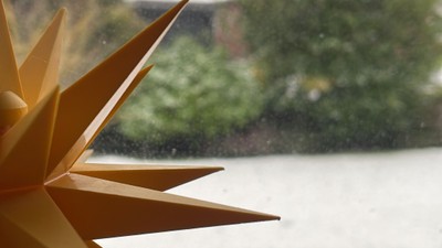 Ein goldener Stern vor einem Fluss und Bäumen