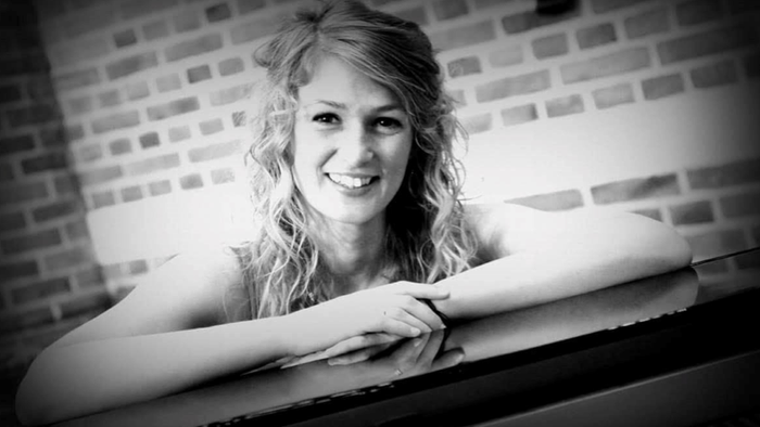 Ung kvinde med krøller og bare arme. Sort hvidt foto