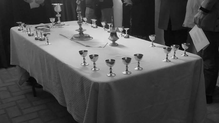 En lang bord med mange glase og skåler på.