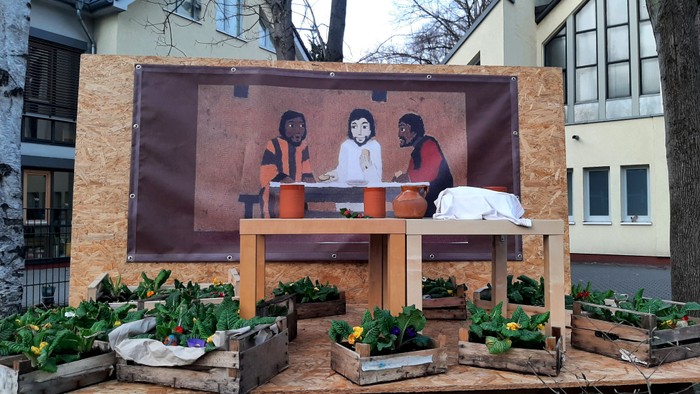 Ein Holzgerüst mit Gemüsebeeten und einem Bild von drei Personen