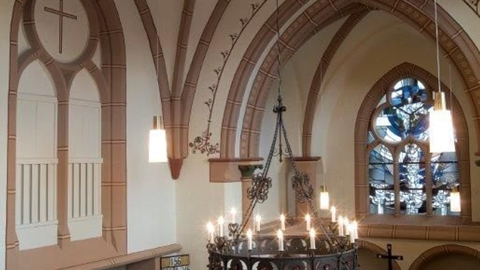 Kircheninneres mit gewölbten Decken, Kronleuchter und Buntglasfenstern