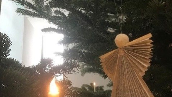 Engel foldet i samletekst og lys på juletræ samt anker i vinduet