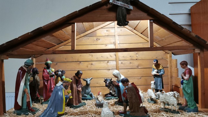 Die Krippe zeigt die Geburt Jesu mit Figuren in einer Holzscheune.