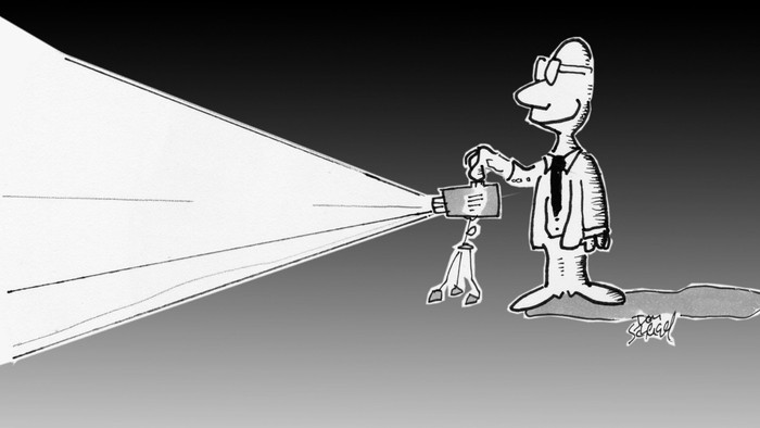 Ein Mann mit Helm leuchtet mit einer Taschenlampe eine Wand ab.