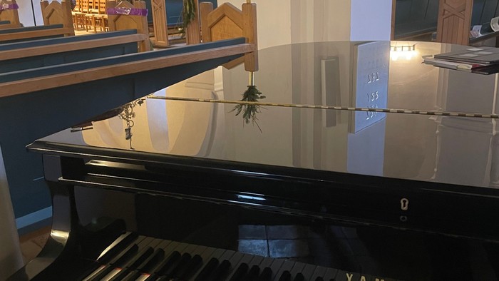 Flygel med advent-pynt i baggrunden