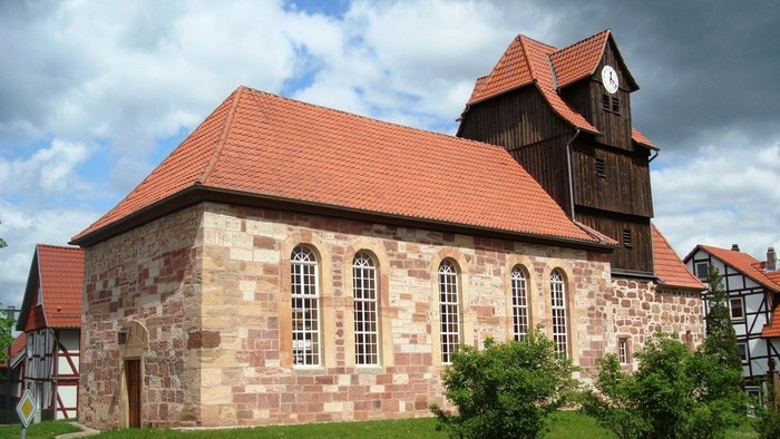 Bild zeigt die Außenansicht der Kirche in Niederdünzebach bei Sonnenschein.