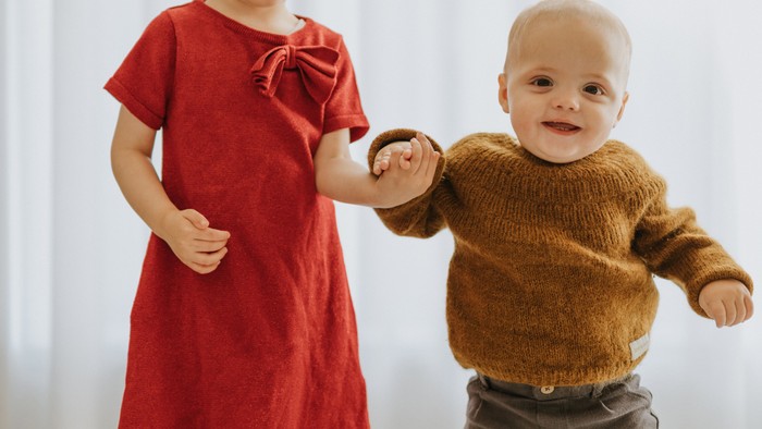 To børn danser sammen i et lys rum