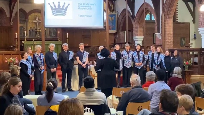 Church choir performing on stage with audience seated.