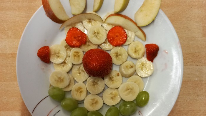 Ein Teller mit Obstarrangement auf einem Holztisch