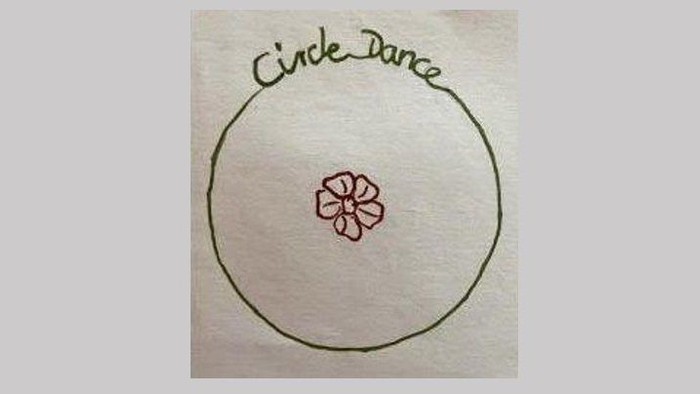 Ein Kreis mit einer Blume und der Aufschrift "Circle Dance".