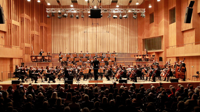 Ein großes Orchester spielt vor vollem Saal