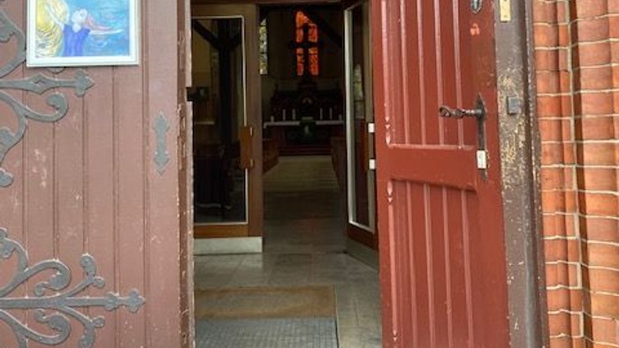 Offene rote Tür an einem Gebäude