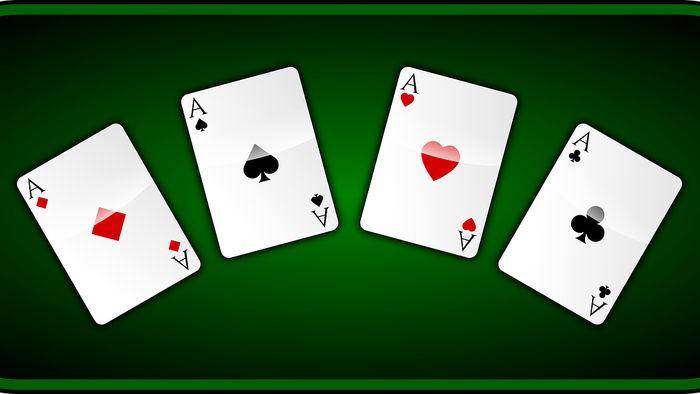 Vier Karten mit verschiedenen Symbolen auf grünem Hintergrund