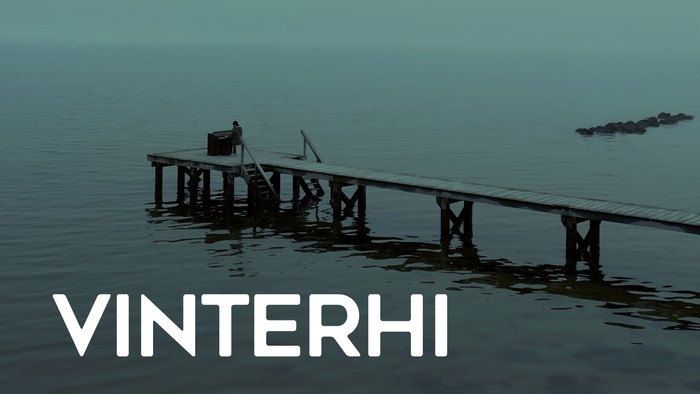 En mole strækker sig ud i stille vand med en båd i nærheden, mærket 