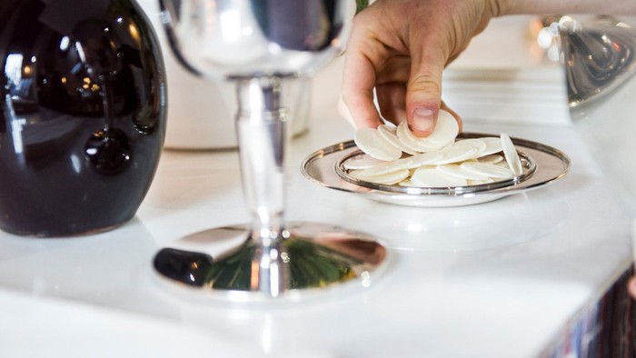 En hånd placerer en skive på en small i forberedelse til madservering