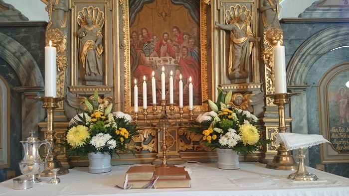 Altaret i kirken med blomster og lysestage