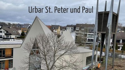 Häuser und Kirche in einem Wohngebiet bei bewölktem Himmel