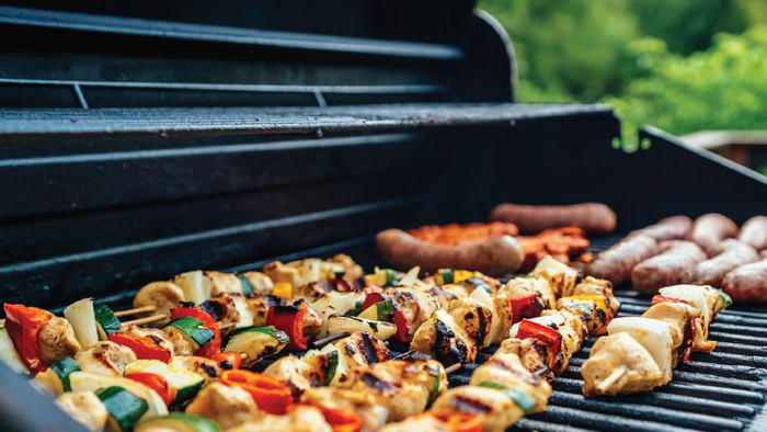 Grillen mit Fleischspießen und Würstchen auf einem Holzkohlegrill
