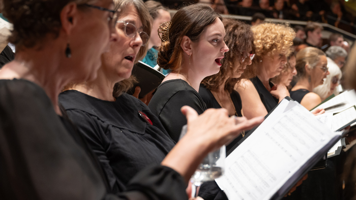 Ein Chor tritt gemeinsam auf und singt während eines Konzerts nach Noten.