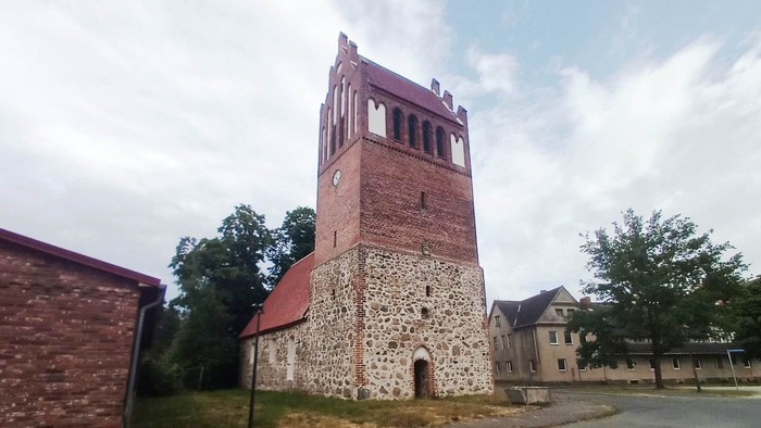 Alte Kirche mit Turm und Ziegelmauer in kleiner Stadt