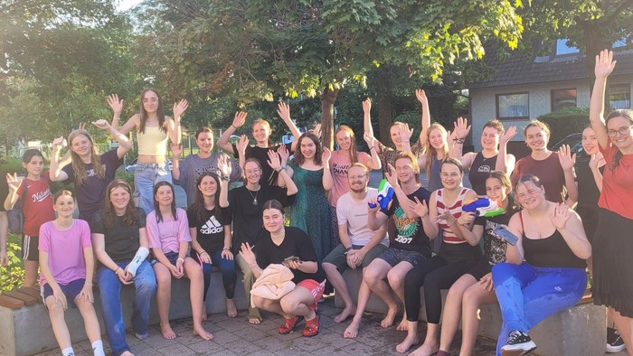 Eine Gruppe von Menschen feiert draußen gemeinsam