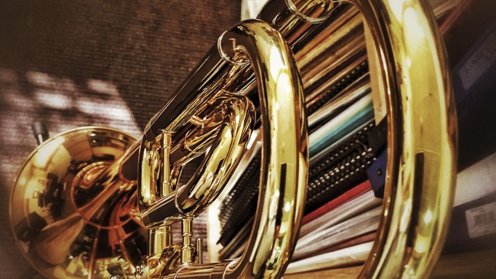 Ein goldenes Saxophon liegt auf einem Bücherstapel