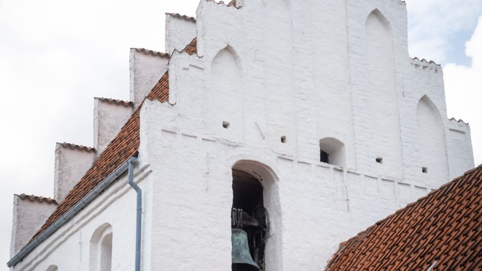 Hvid kirke med spisse tårne og røde tagfliser.