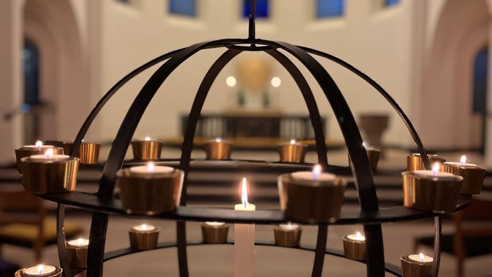 En kandleholder med flere lyse lygter i en kirke