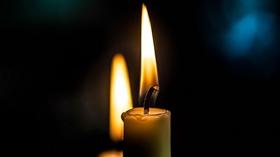 To candler med lysende flammer på mørk baggrund