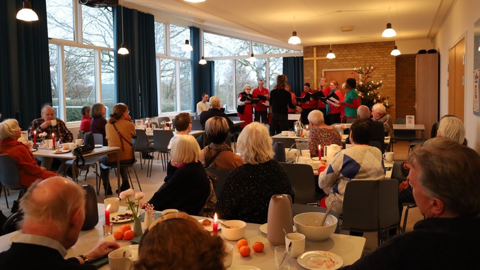 En gruppe mennesker, der spiser og socialiserer i et veloplyst spisområde.