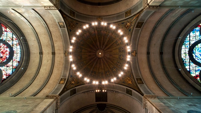 Die Decke einer Kirche mit Kuppel und farbenfrohen Buntglasfenstern