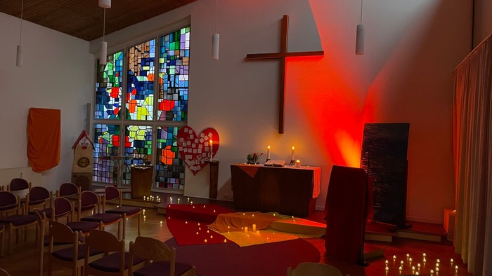 Kirchliche Innenraum mit buntem Fenster, Kreuz und Kerzenlicht