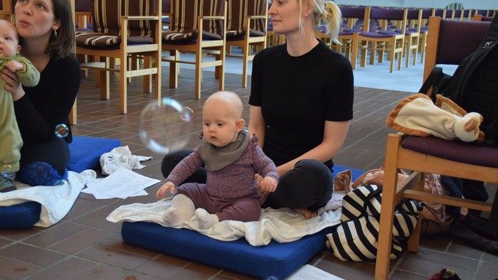 To børn og to kvinder i kirke.