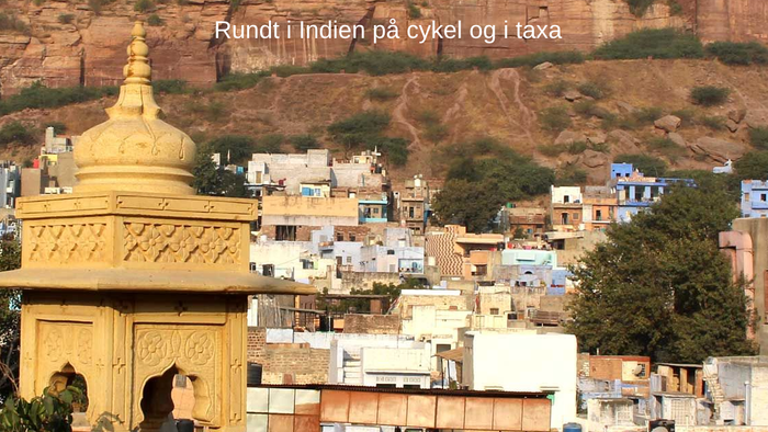 En indisk by med en guld farvet tempel og farvede huse i bakgronden