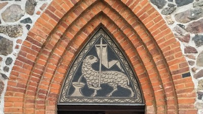 Eingangstür der Dorfkirche Alt-Wittenau, über der Tür ein Opferlamm