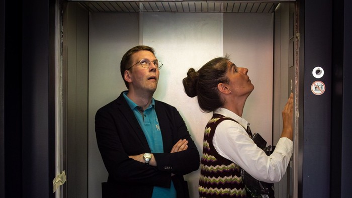 Ein Mann und eine Frau stehen im Fahrstuhl